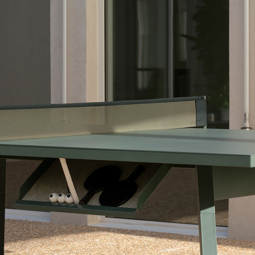 Detalle de mesa de ping pong exterior RS Barcelona con raquetas y pelotas.